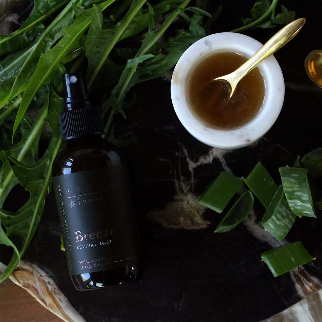 4 oz bottle of the Breeze Toner on a counter with herbs and a tonic