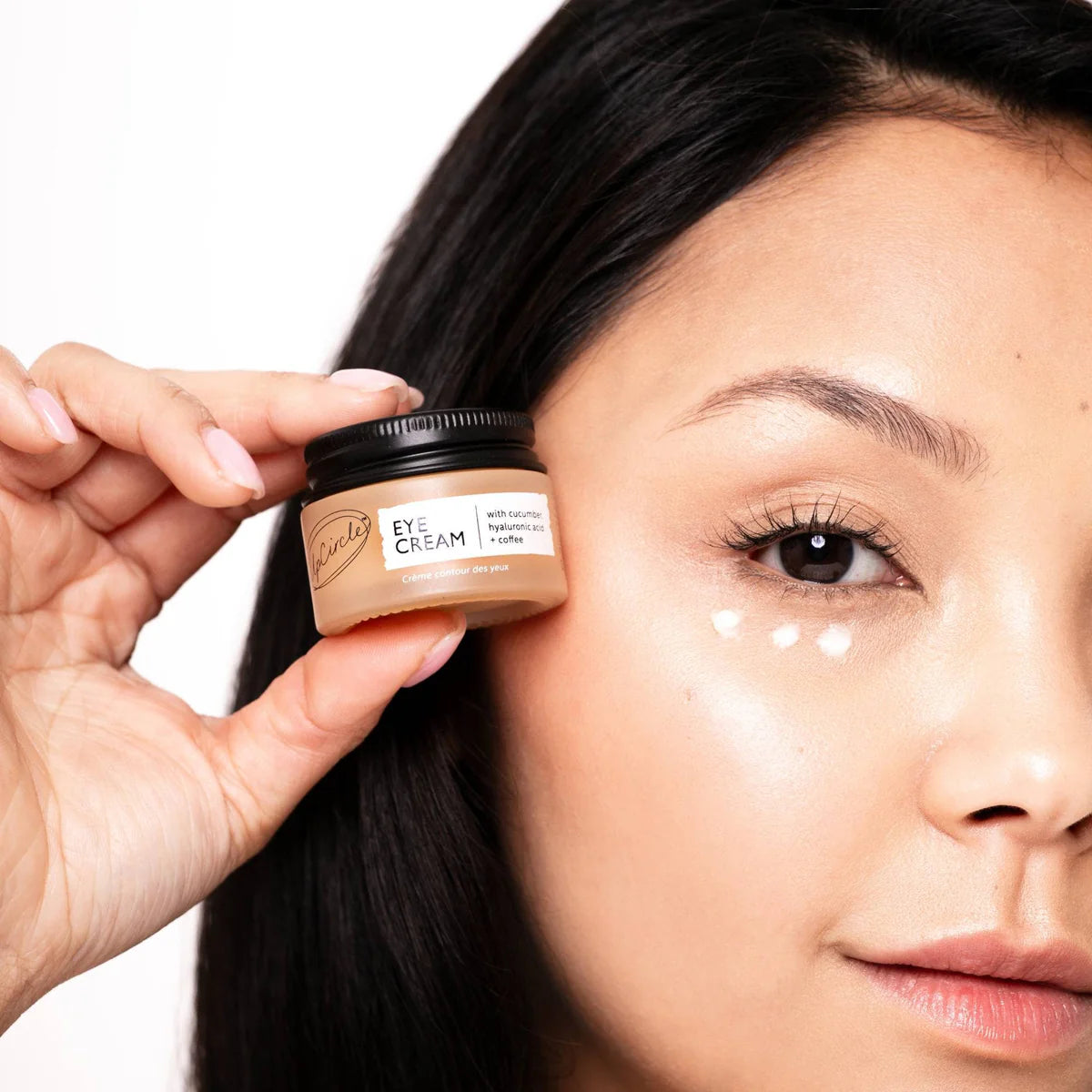 Woman holding up jar of Eye Cream Hyaluronic Acid from UpCircle Beauty