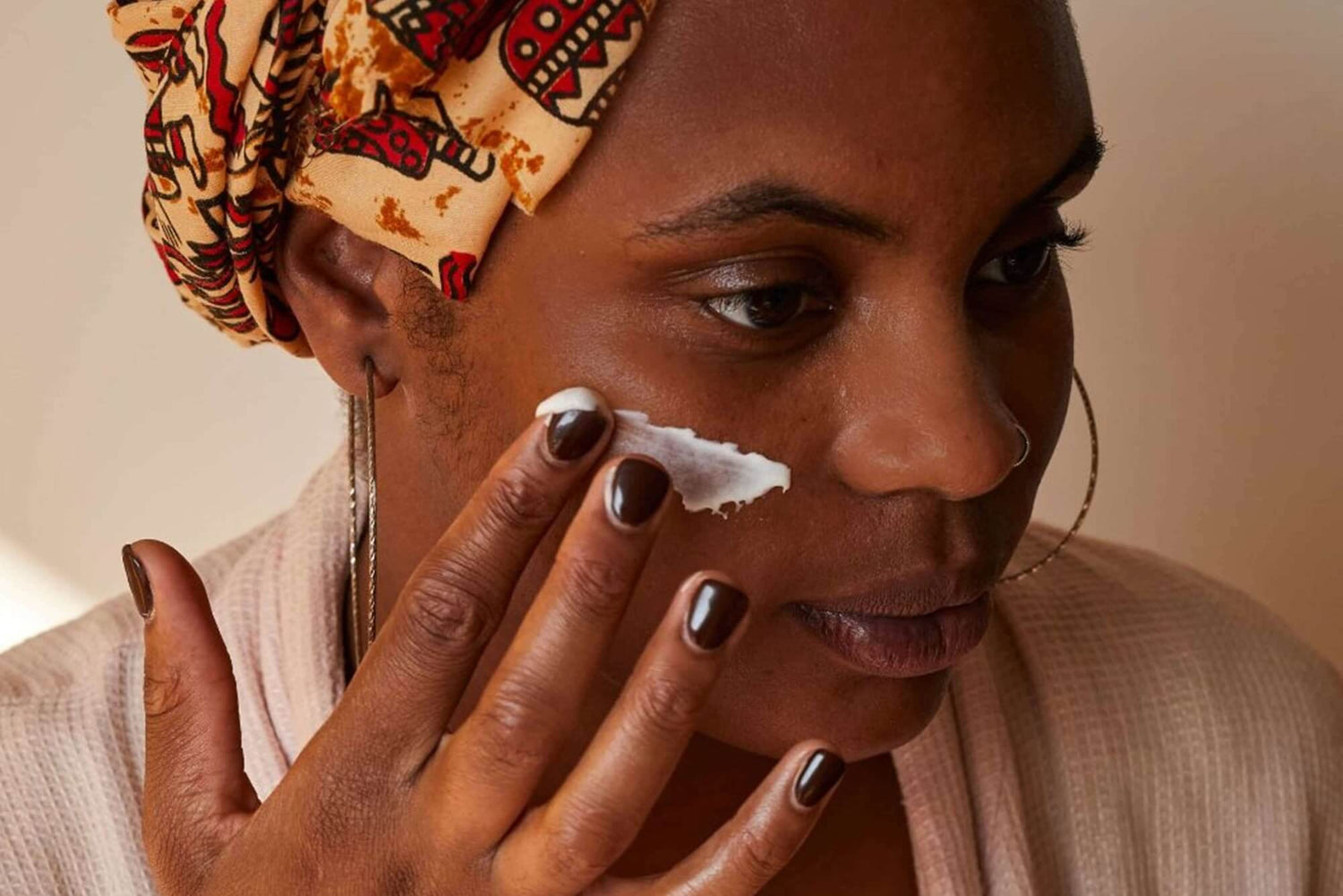 Woman applying the UpCircle Vitamin E Face Cream to her face as part of a detoxifying skincare routine