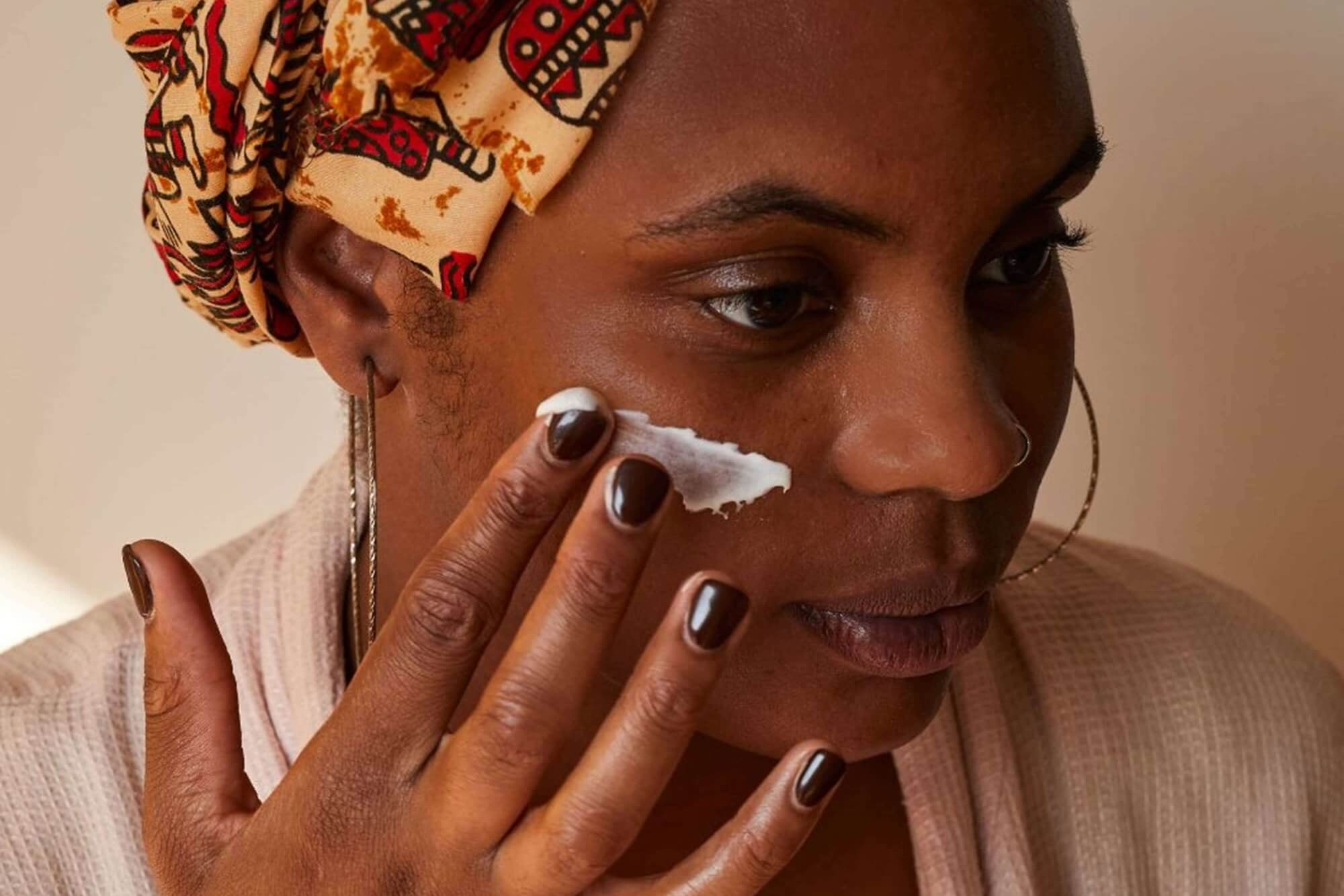 Woman applying the UpCircle Vitamin E Face Cream to her face as part of a detoxifying skincare routine