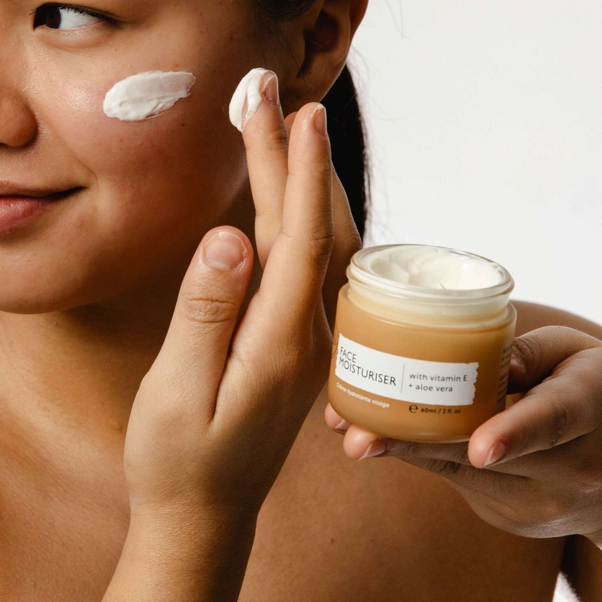 Woman with jar of UpCircle Vitamin E Face Cream with Aloe Vera