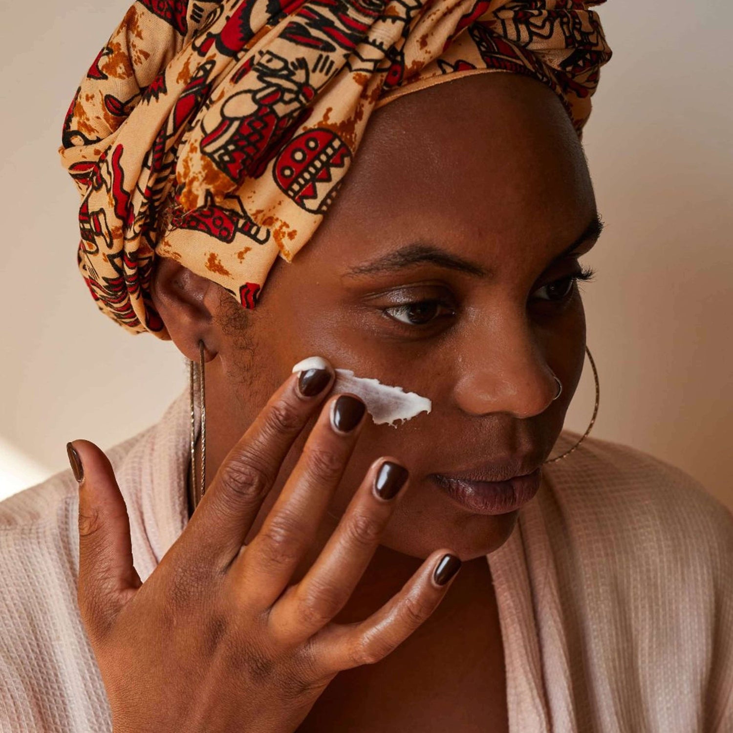 Woman wearing headscarf applying Vitamin E Face Cream with Aloe Vera
