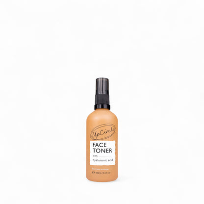Glass spray bottle of face toner with hyaluronic acid from UpCircle on a white background