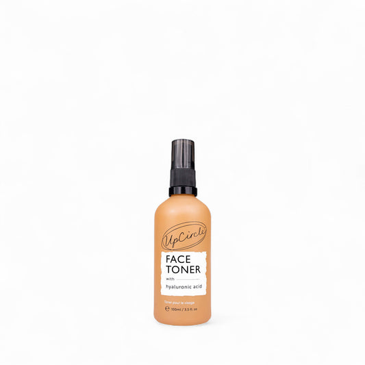 Glass spray bottle of face toner with hyaluronic acid from UpCircle on a white background