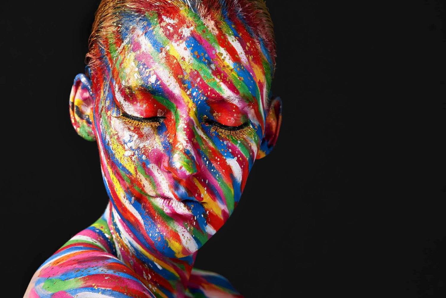 Colorfully painted face and shoulders of a woman