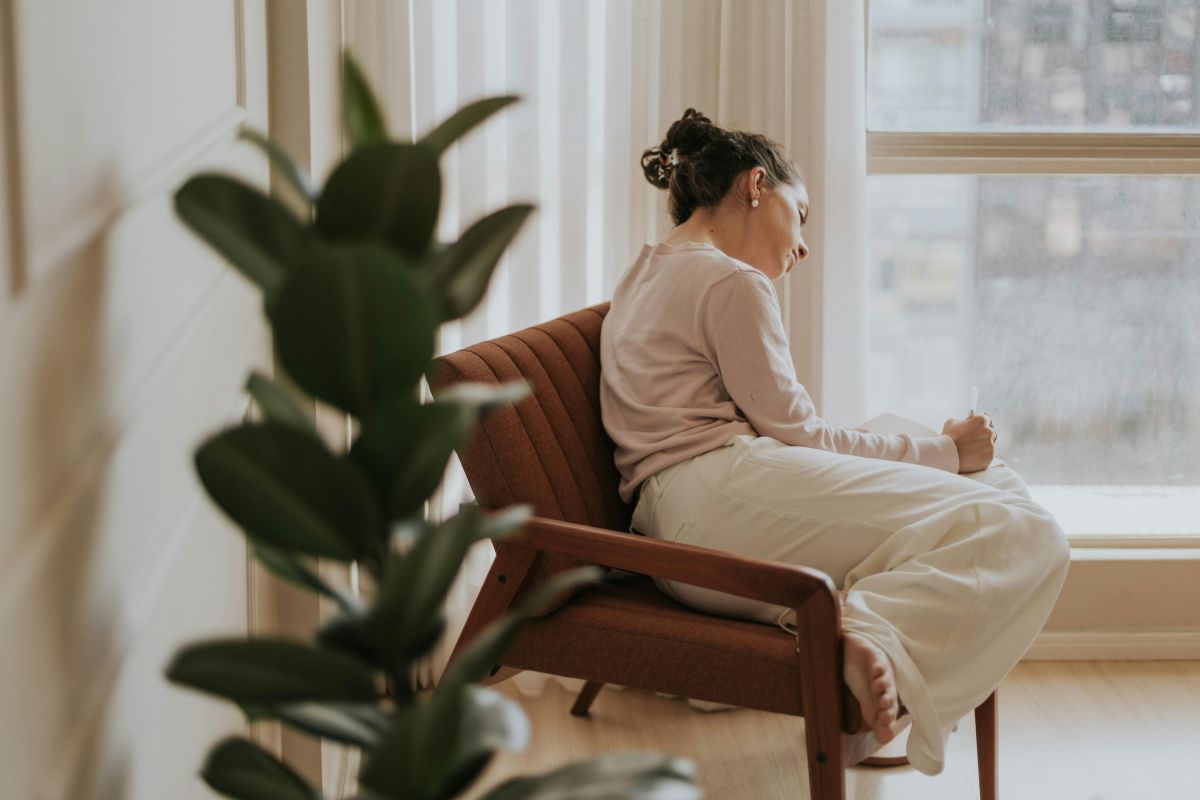 Woman relaxing with her journal in a cozy room near a window
