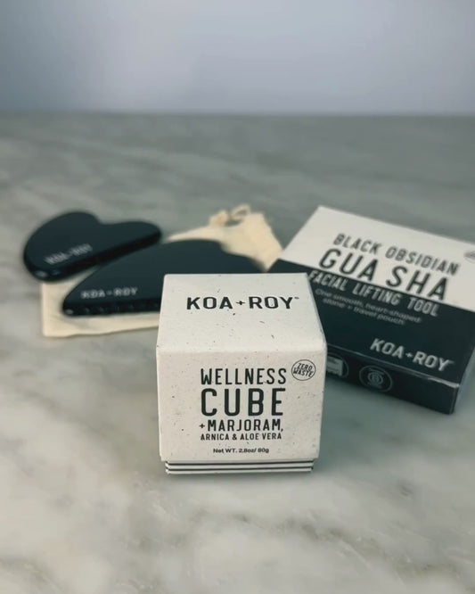 Woman demonstrating use of the Wellness Cube with the Gua Sha. 