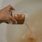 Hand pouring the Rosehip Bath Salts into a bathtub