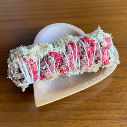 White Sage + Dried Tansy with Red Statice Smudge Stick in a heart tray on a table