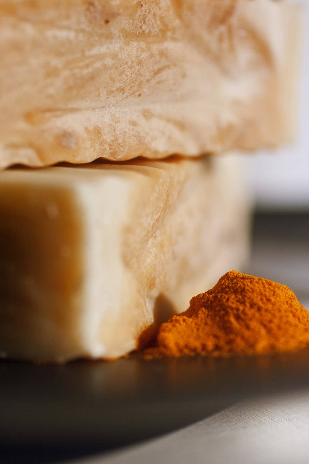 Close up shot of soap with a pile of turmeric beside them