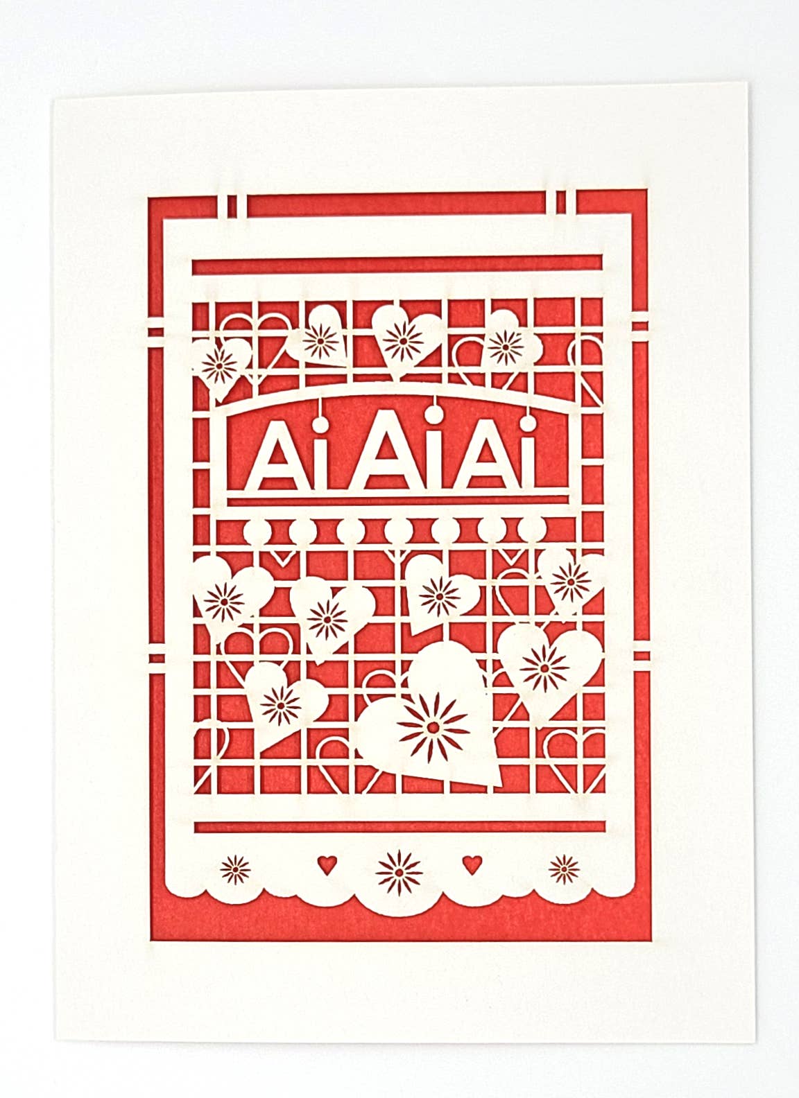 Greeting card with a laser cut image of hearts on white with red background