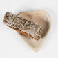 Hand carved heart-shaped dish in natural stone with smudge stick