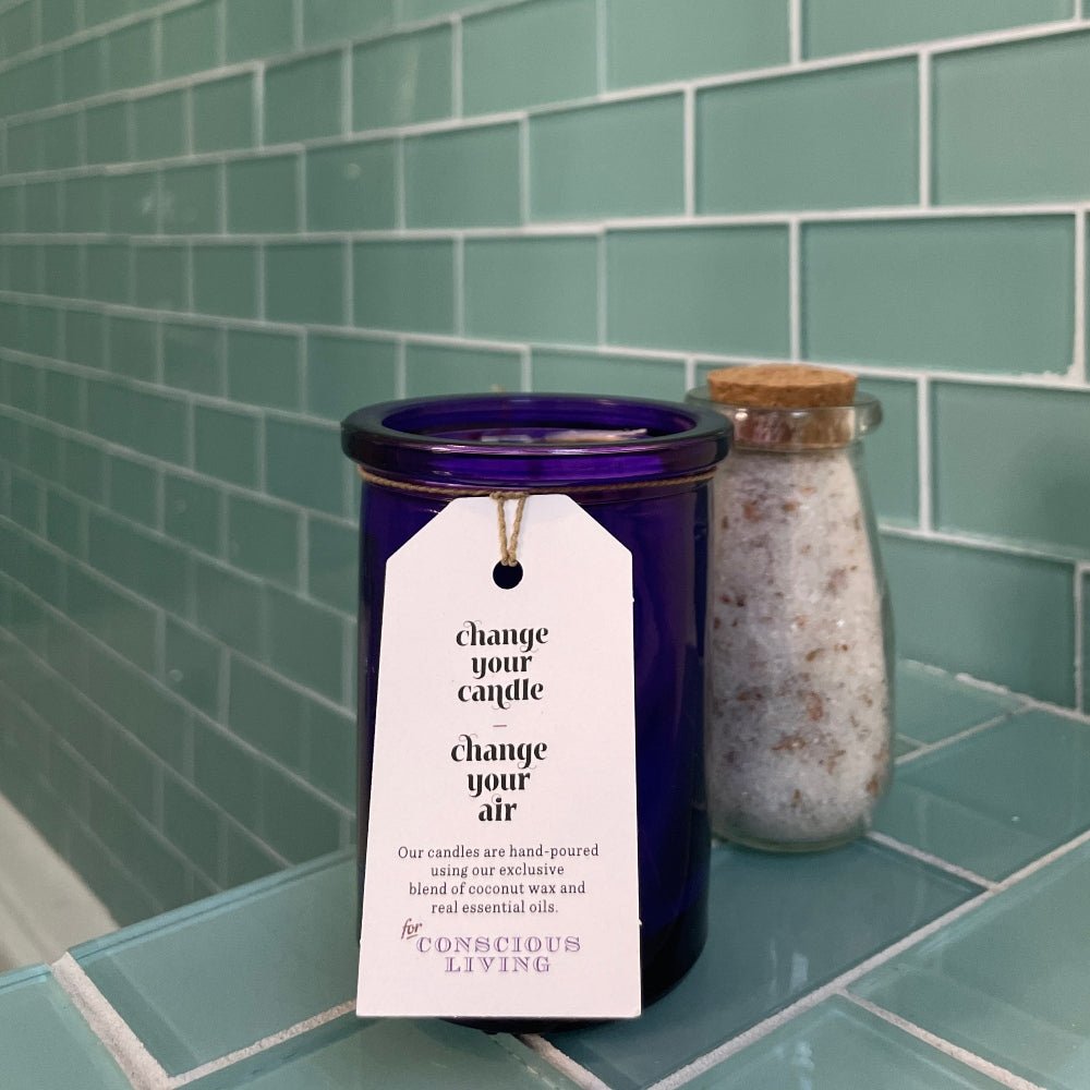 Wildcrafted French Lavender Candle on a bathroom counter with bath salts in background